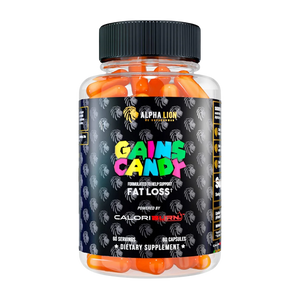 A clear plastic bottle of Alpha Lion Gains Candy dietary supplement capsules, filled with bright orange capsules and featuring a black label with colorful text.