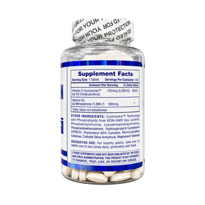 A clear supplement bottle with a white cap and a blue label showing Supplement Facts, filled with white tablets. The label includes text for Vitamin D chloride, Vitamin K2, and lists ingredients and usage information.